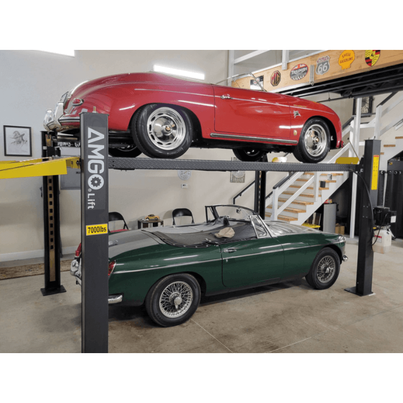 Two classic cars stacked on heavy-duty garage lift. 