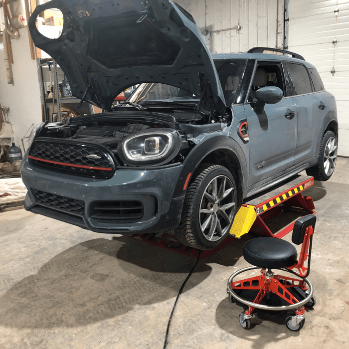 Mini Cooper on lift with hood opened.