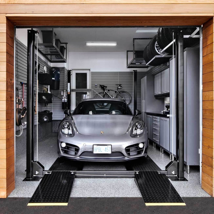 Modern garage with Porsche on lift and organized storage setup.