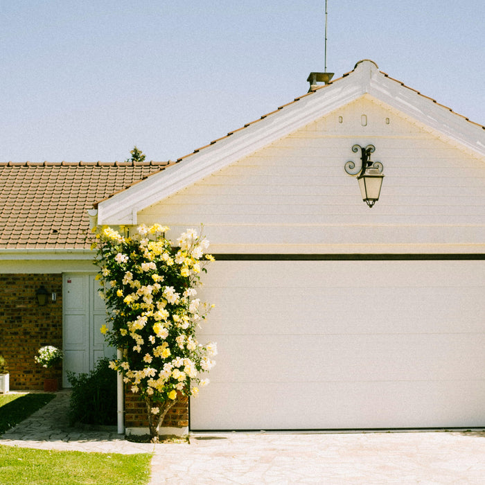 Brick house with two-car garage and yellow flowers.