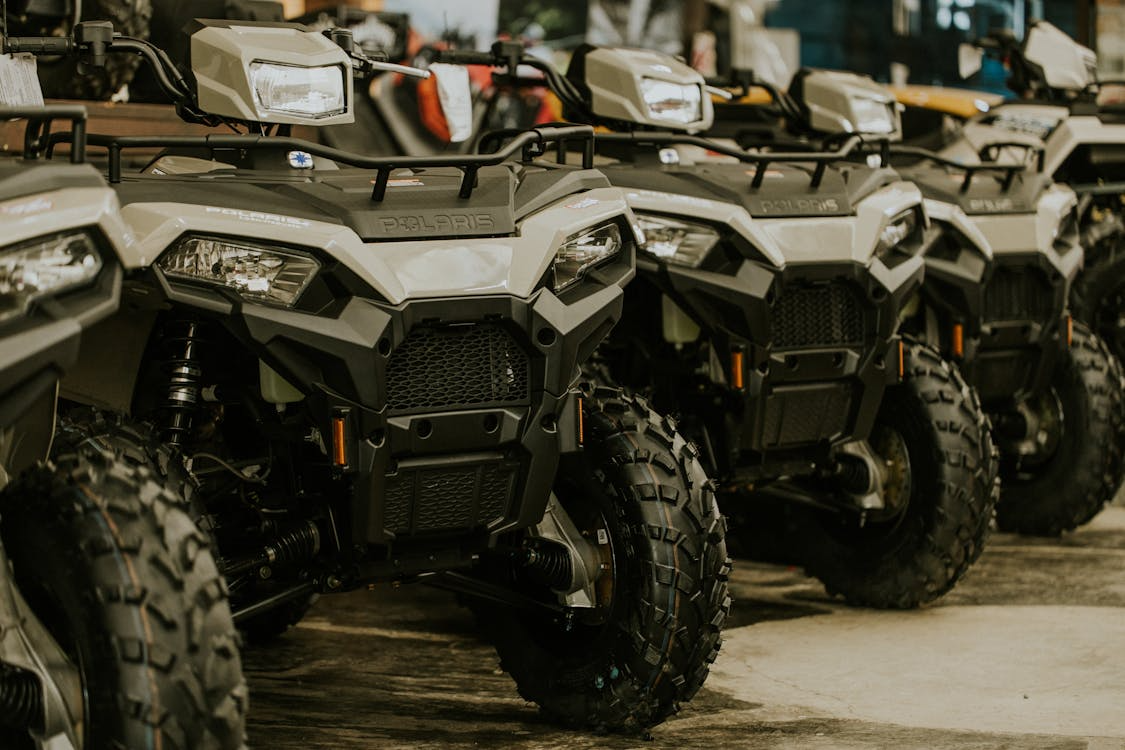 Row of white and black ATVs displayed.