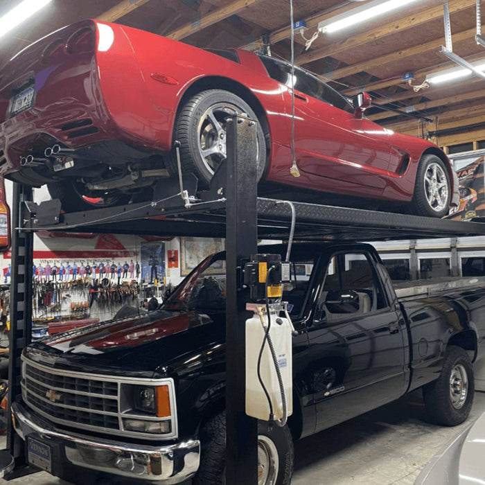 Corvette lifted above vintage Chevy truck in home garage.