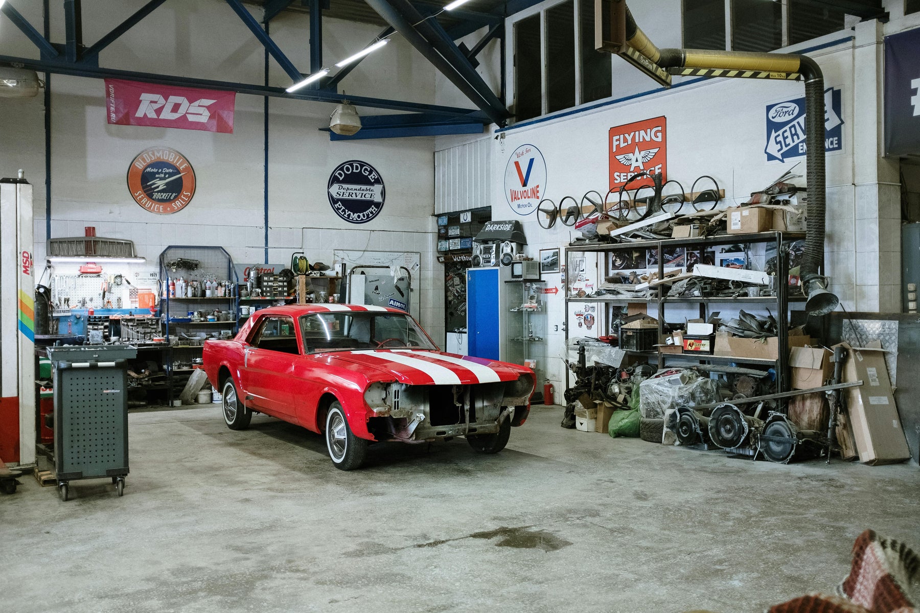 Red and white vintage car in a restoration garage workshop.