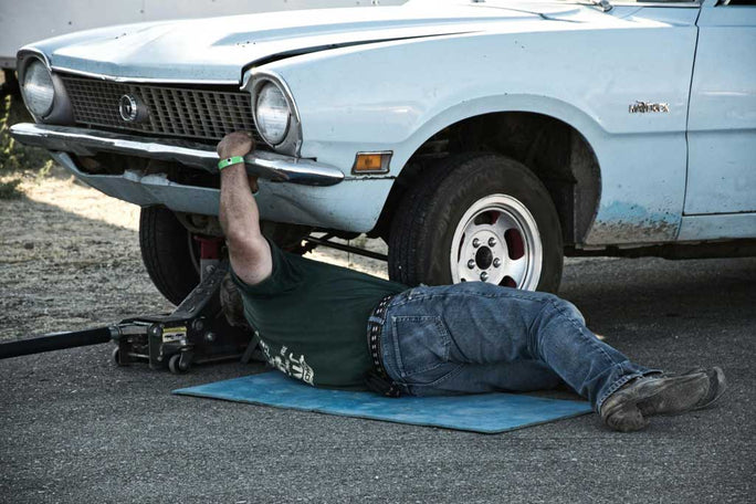 Mechanic working under car with floor jack